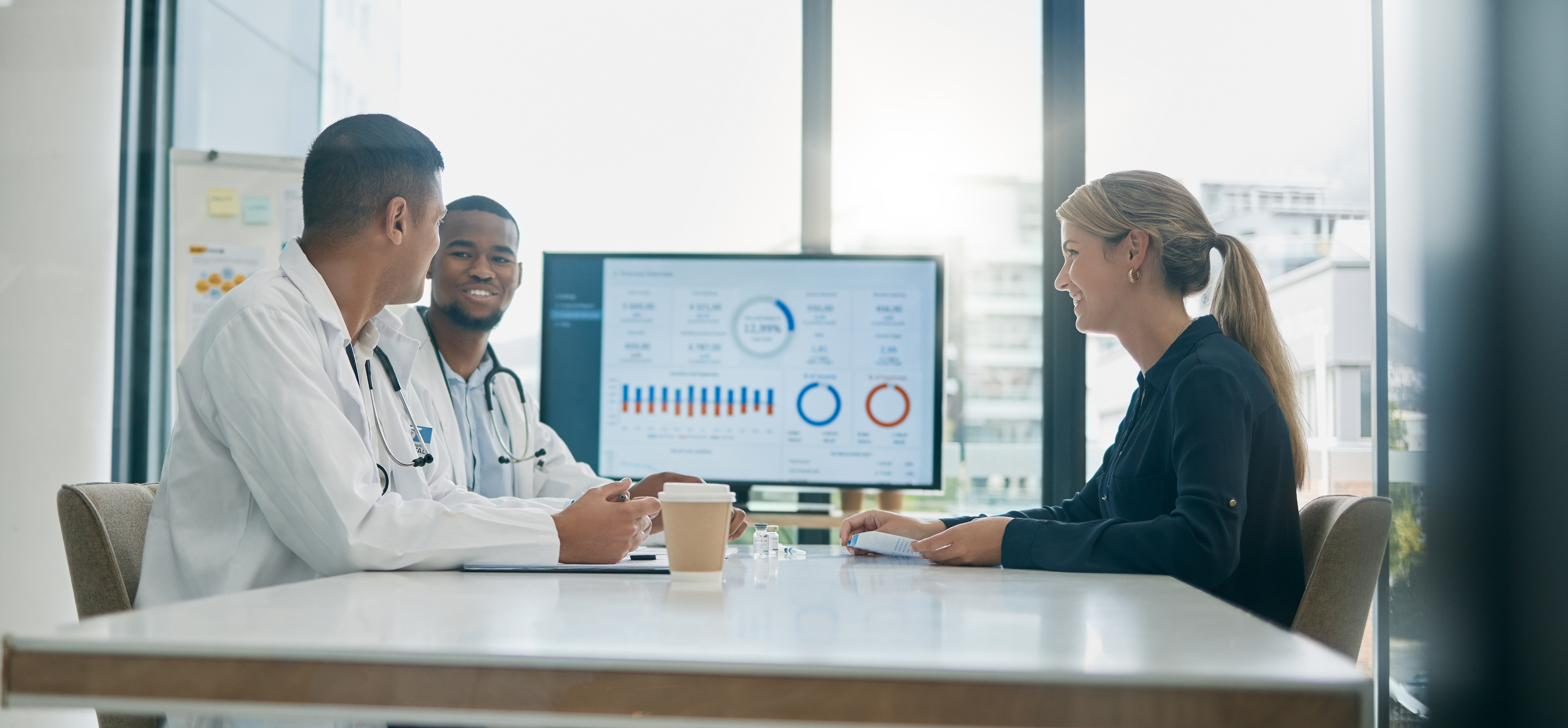 Healthcare leaders and HealthOps consultants reviewing an operations dashboard together