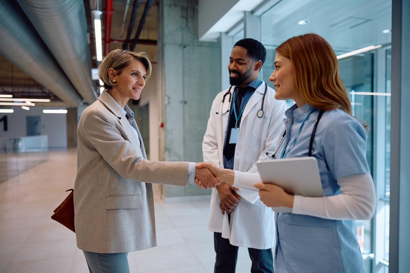 A consultant shaking hands with clinical staff in a healthcare facility